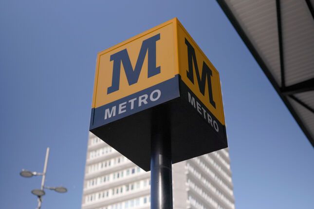 The Metro cube sign in the sky aligned with some high rise flats