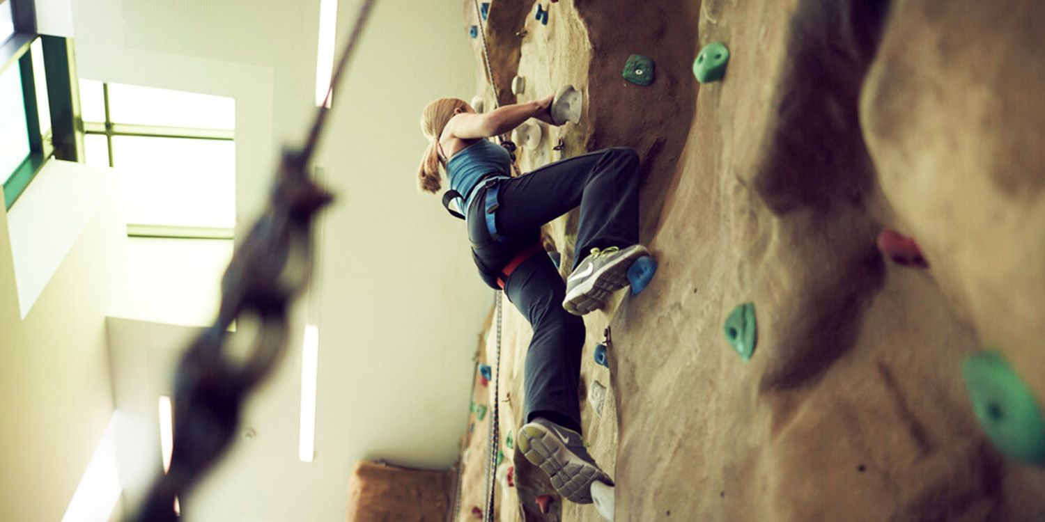 A student climbing the climbing wall at CitySpace