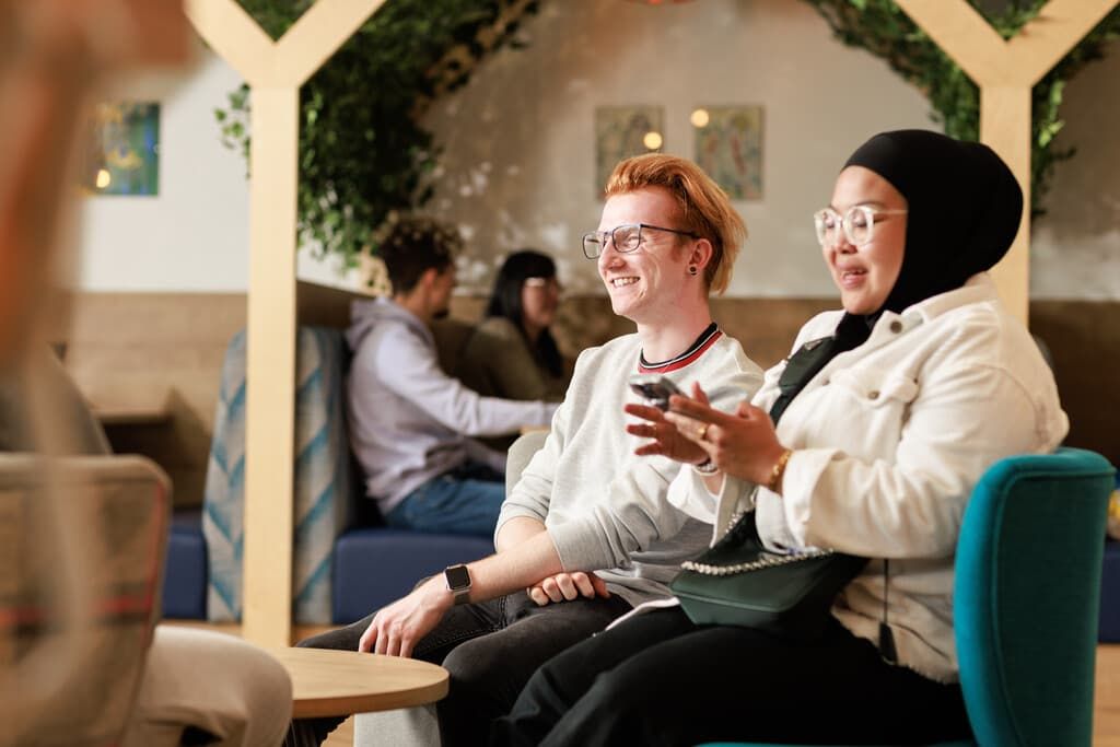 Two students sitting in a campus cafe chatting