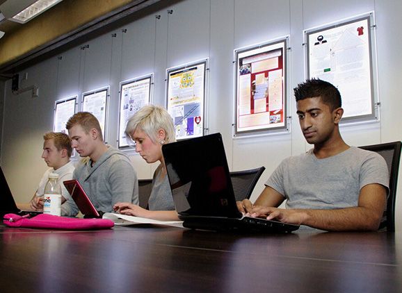 Students sitting in a line on laptops