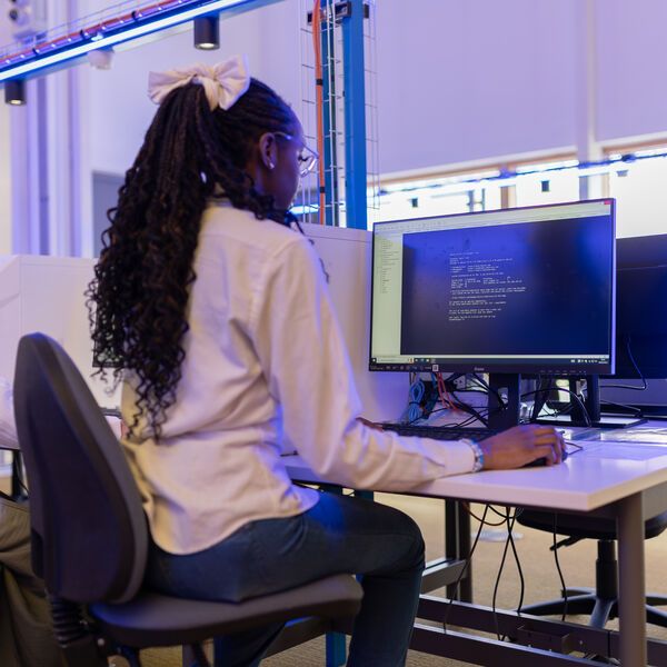 A computer science student working at a desktop computer