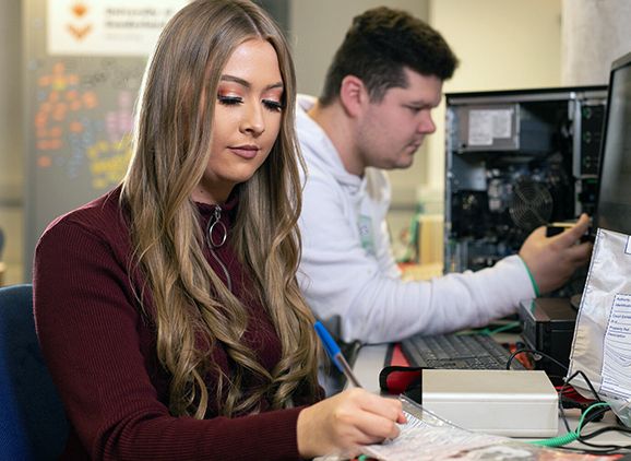Two students looking at computing equipment