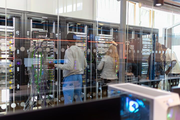 Cybersecurity students working at a server rack