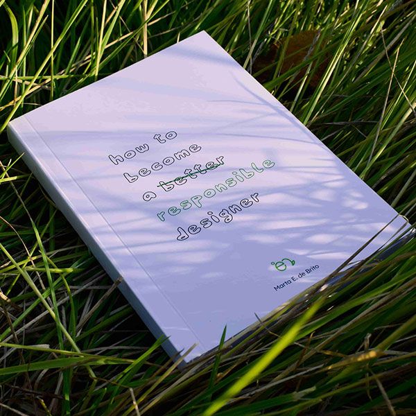 A white file with the words 'How to become a responsible designer' written across it, lying in some grass