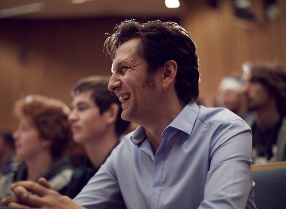 A smiling student in a lecture theatre