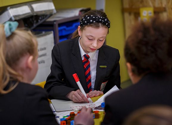 A secondary school pupil writing with a marker pen