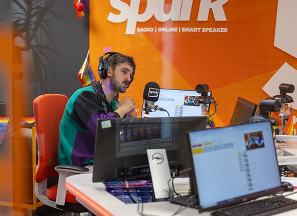 A student speaking into a microphone in a radio studio