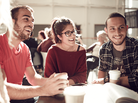 Students laughing together and drinking coffee
