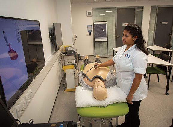 Student using cardiac ultrasound simulator on manikin