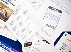 Lots of NHS documents and forms piled together