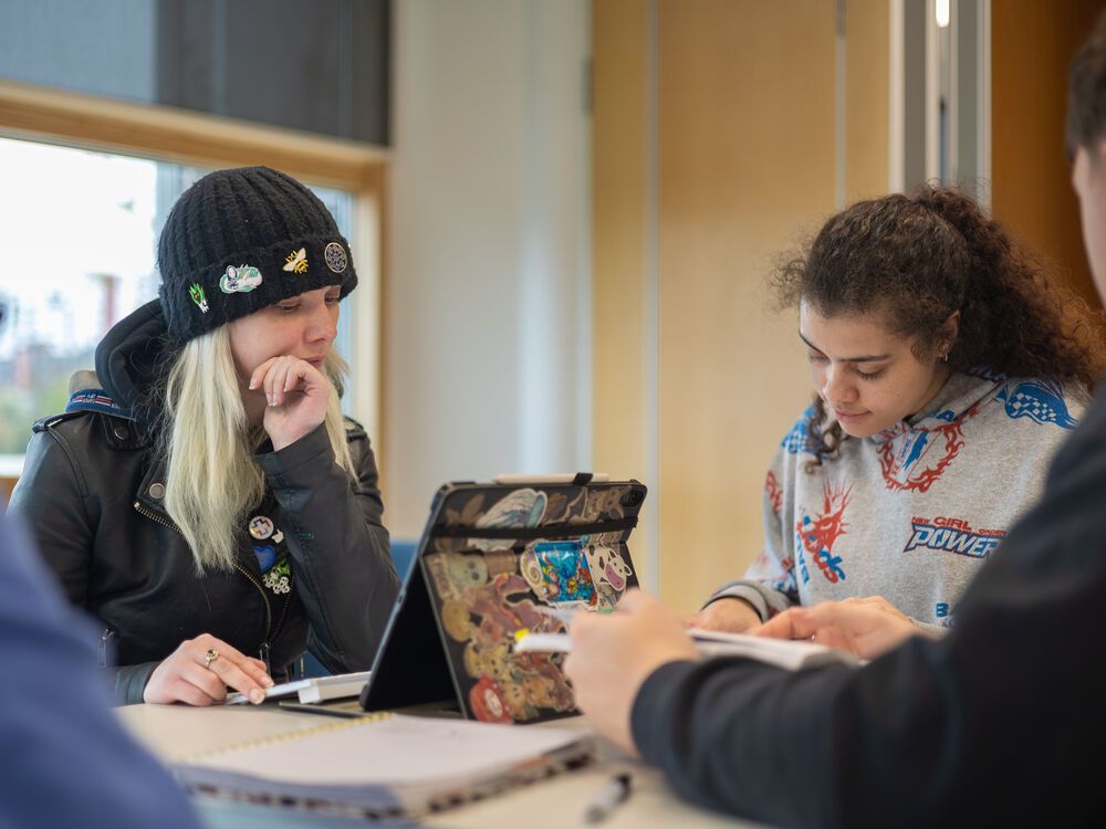 A group of Community and Youth Work apprentices working together around a table