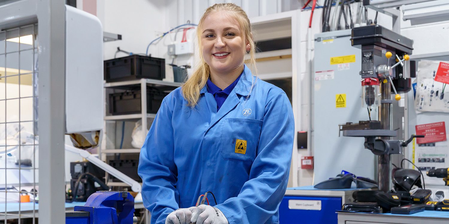 A female engineering student smiling for the camera in the engineering lab