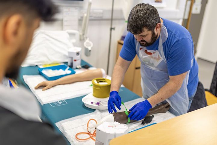 A nursing student completing an arm simulation