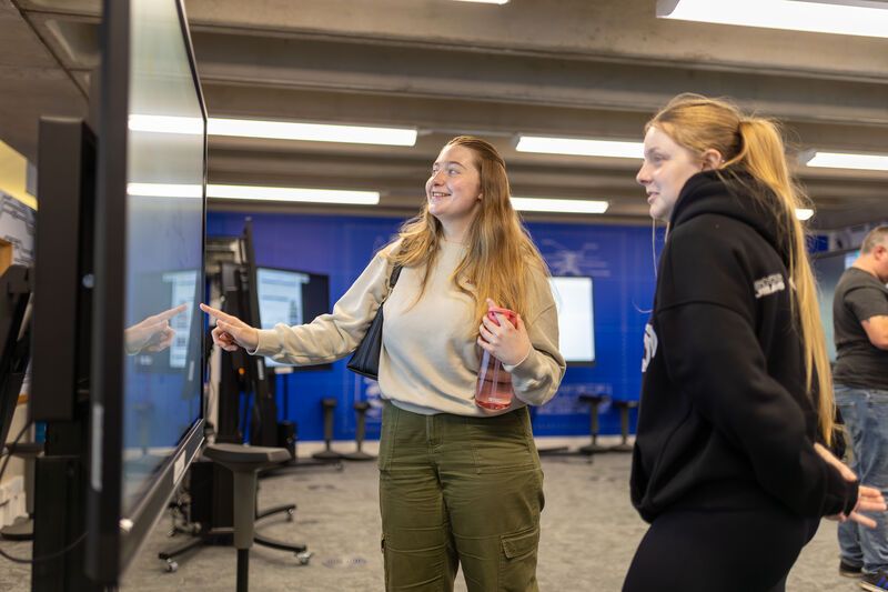 two students discussing the poster in front of them during a presentation