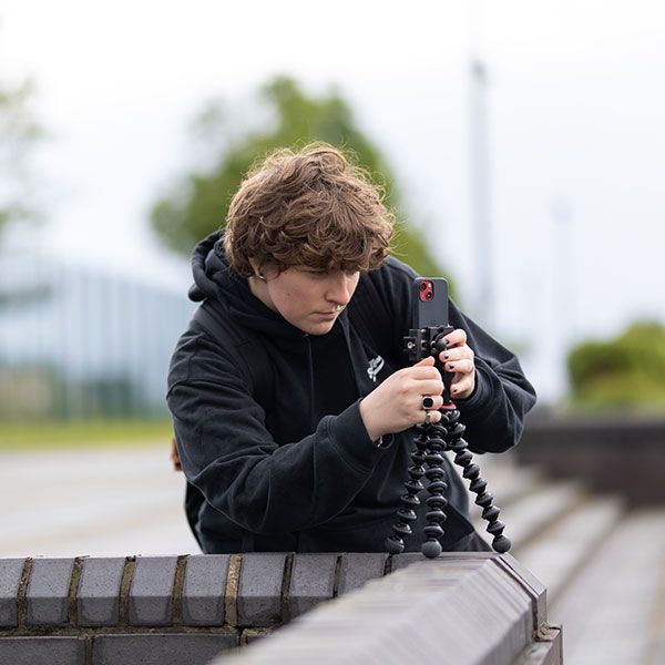 A Social Media Management student filming something on their mobile phone