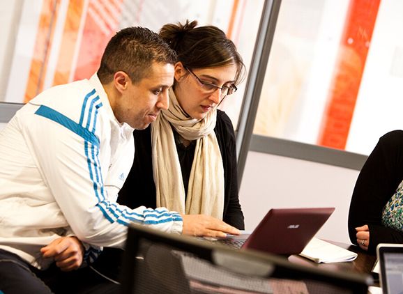 Two students looking at a laptop together