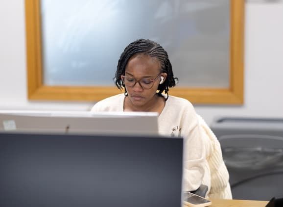 A student working at their laptop looking focused
