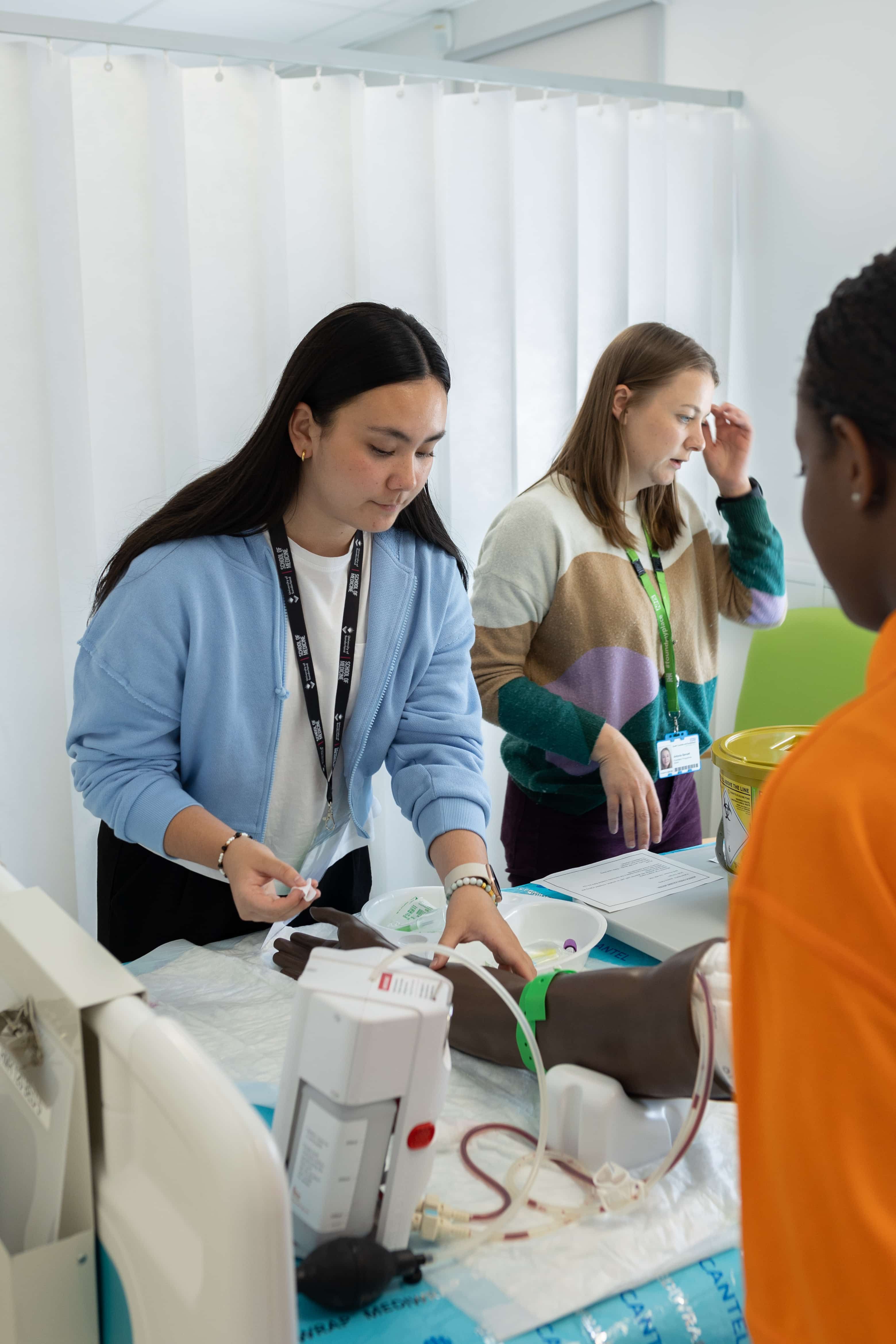 Medstart students working on a Manikin arm during a simulation