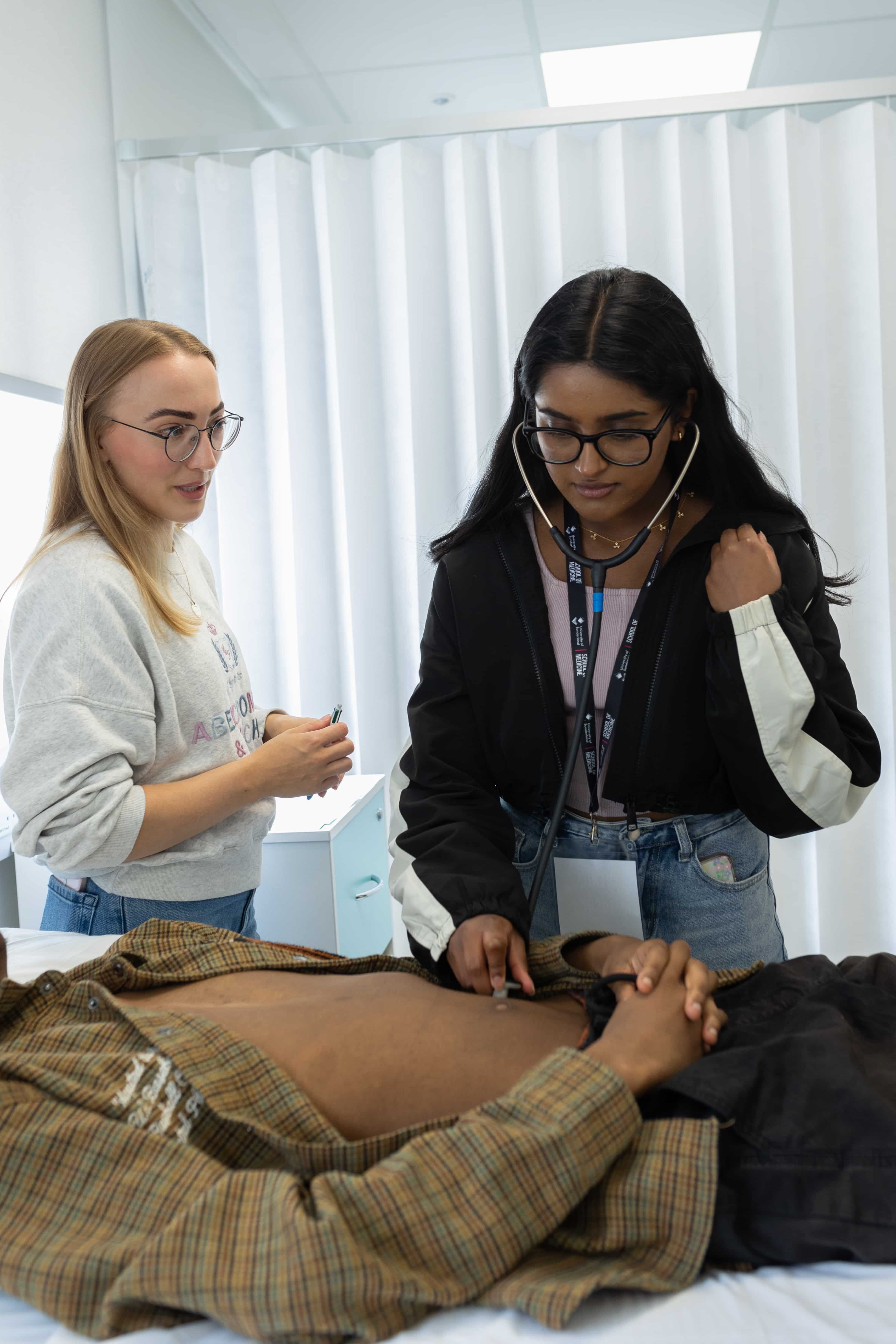 Medstart students using a stethoscope on a patient