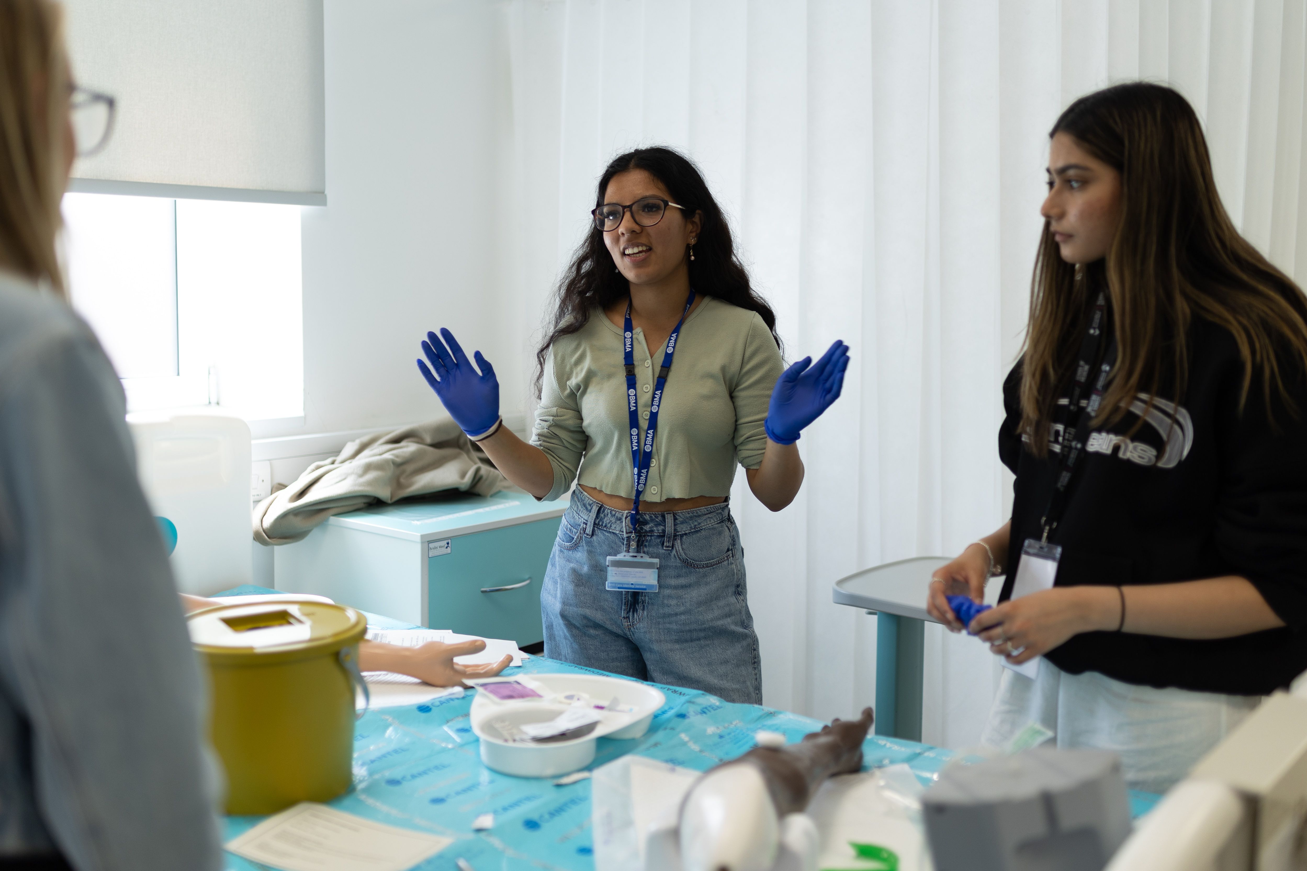 Three medstart students practicing using equipment during a simulation