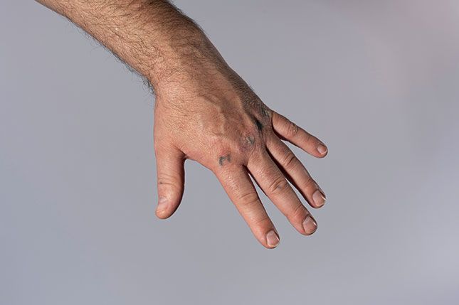 A hand in front of a plain grey background