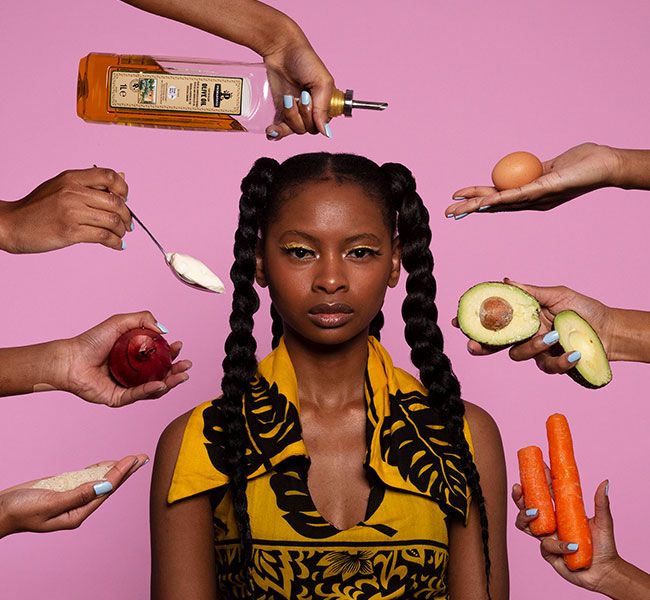 A person facing the camera surrounded by hands holding various foods