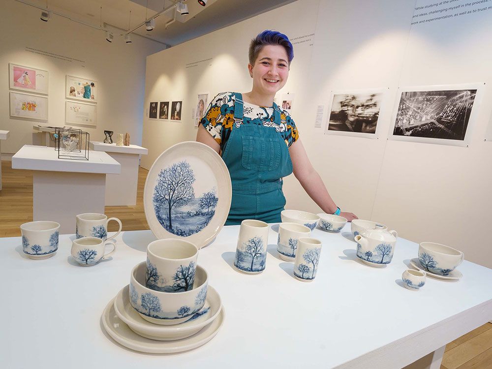 A student standing by their work in the Sunderland Creatives gallery