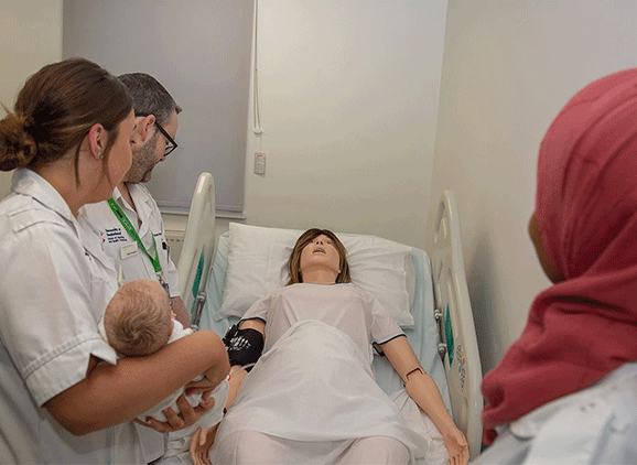 Midwifery students working with the SIM baby and mother in the mock ward