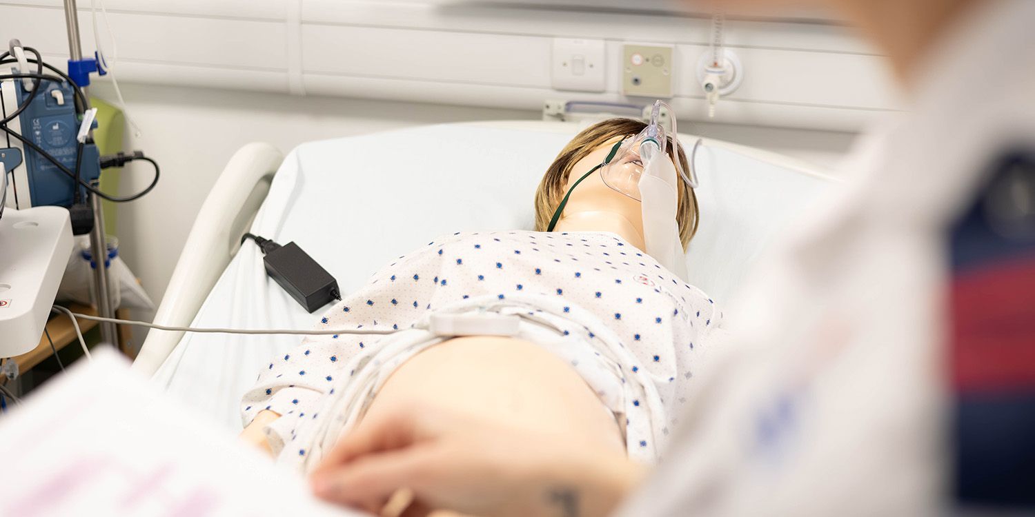 A SIM Mom manikin in a hospital bed