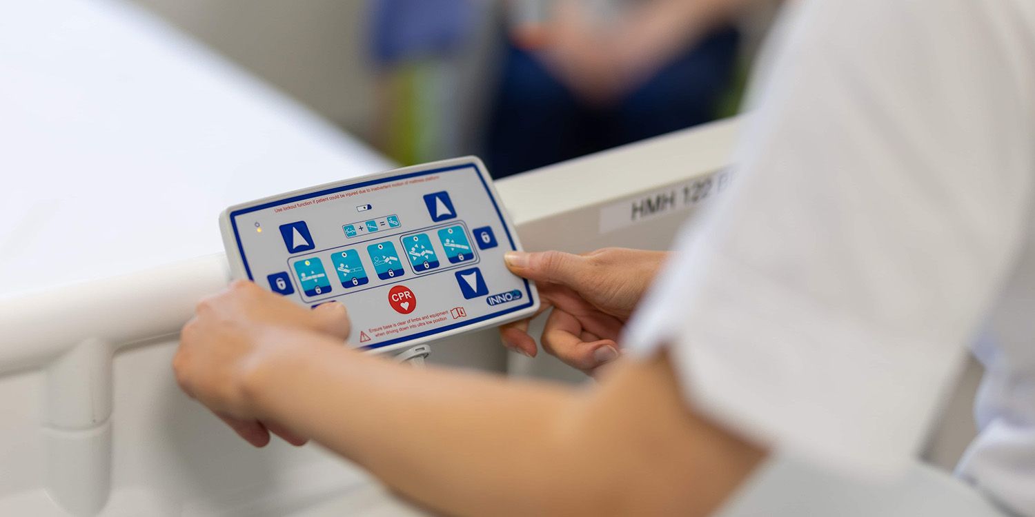 A student nurse adjusting the settings on a mock hospital bed