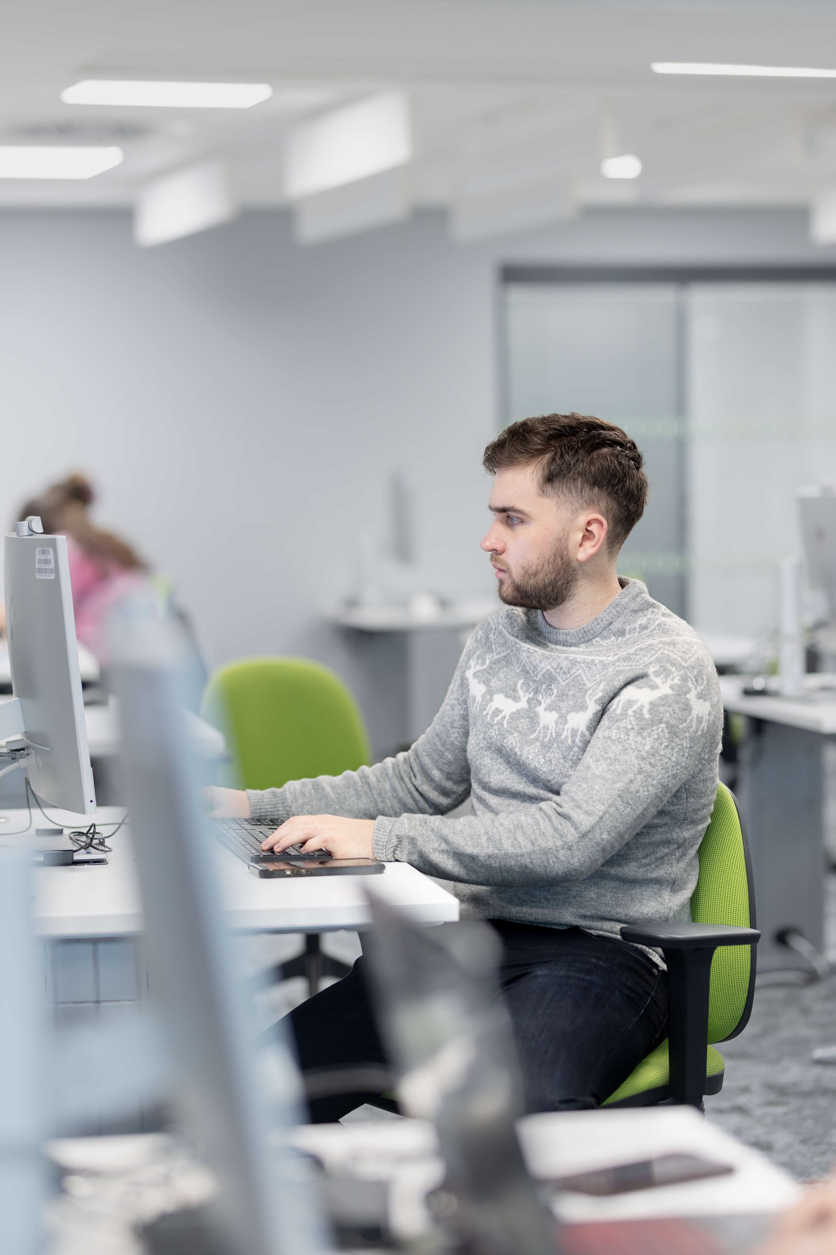 a psychology student sitting at a desk using a computer in the murray health ICT skills lab