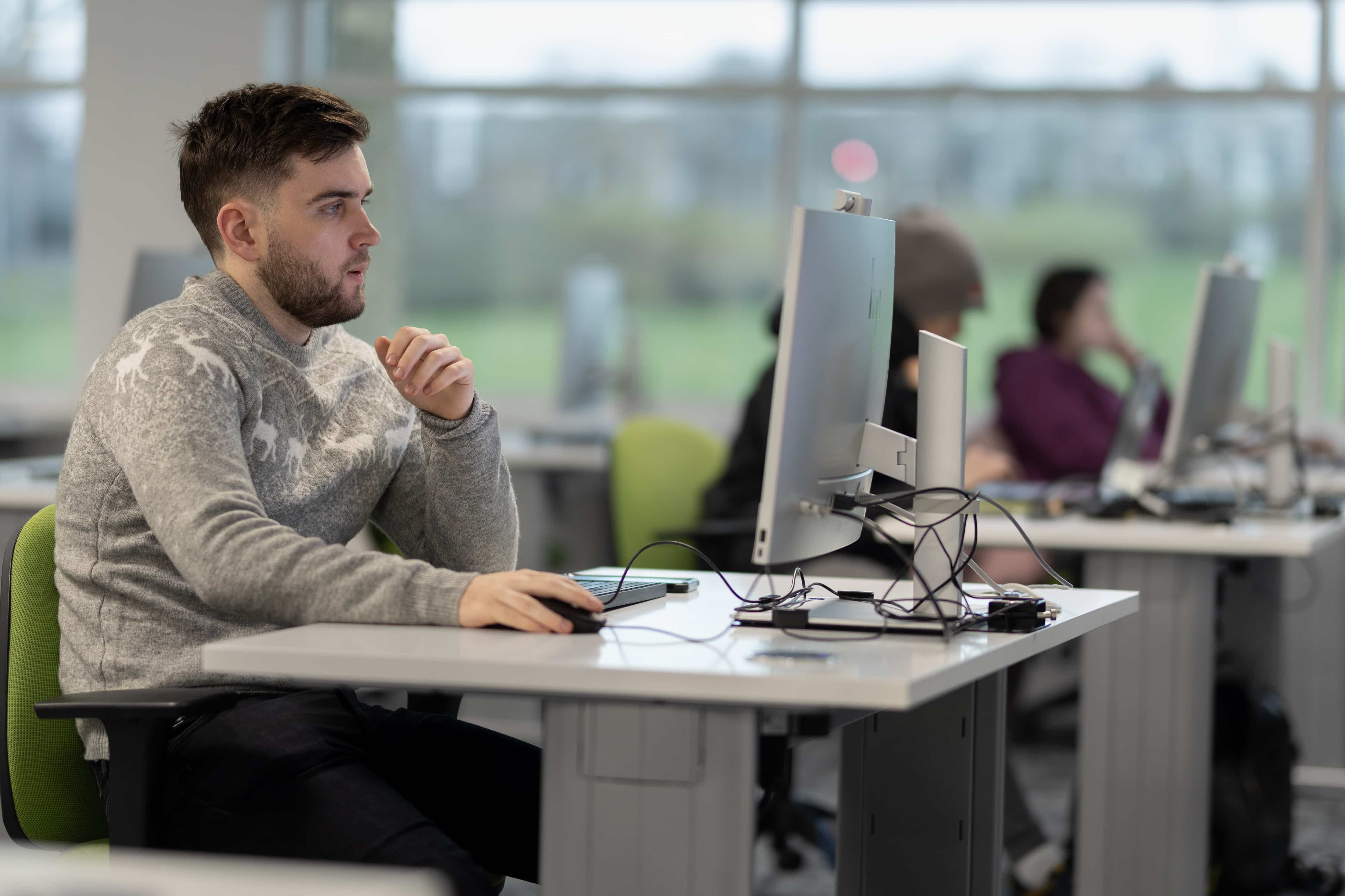 a psychology student sitting at a desk using a computer in the murray health ICT skills lab