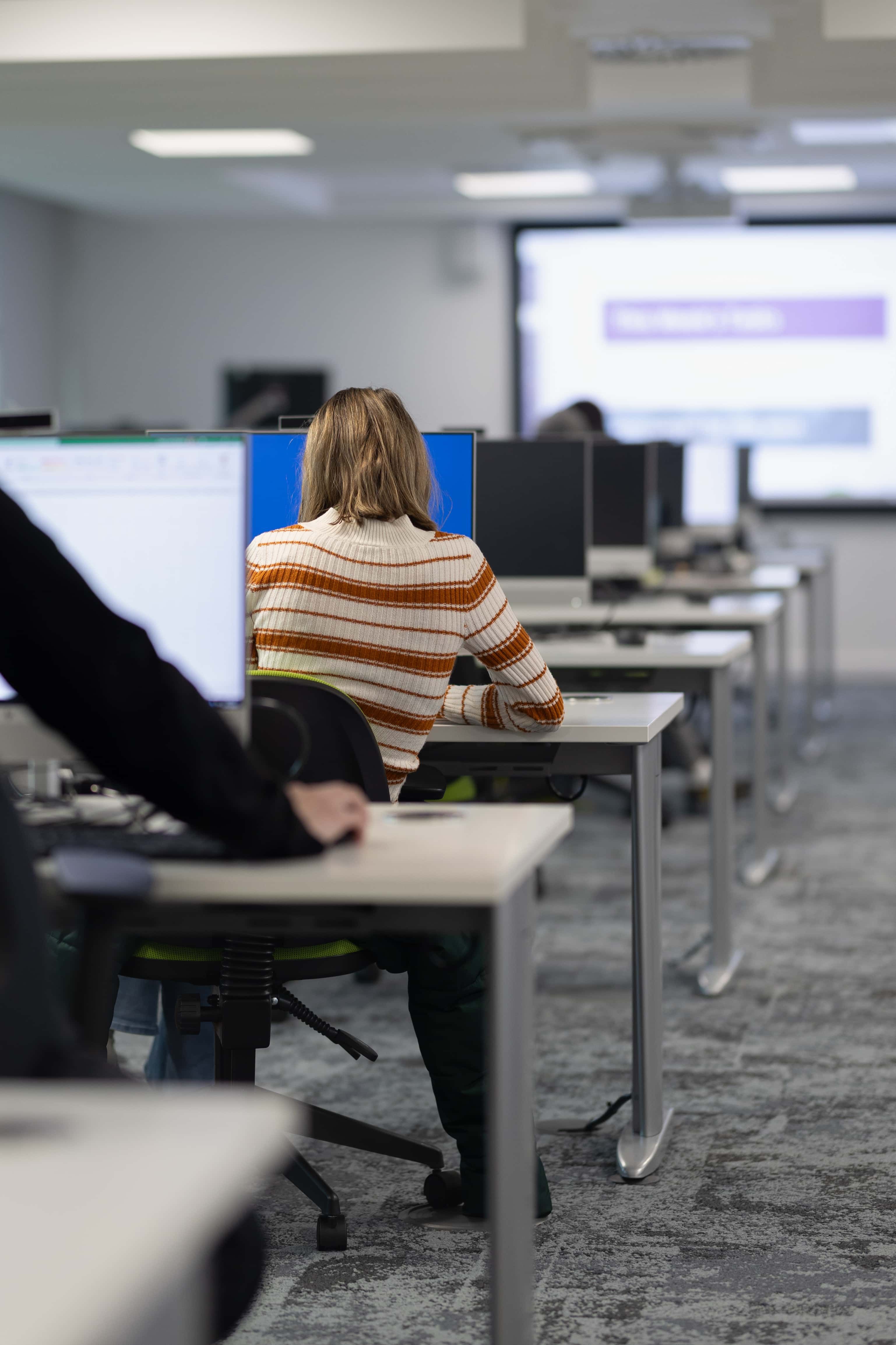 a shot of the back of psychology students sitting and working at computers in the murray health ICT skills lab