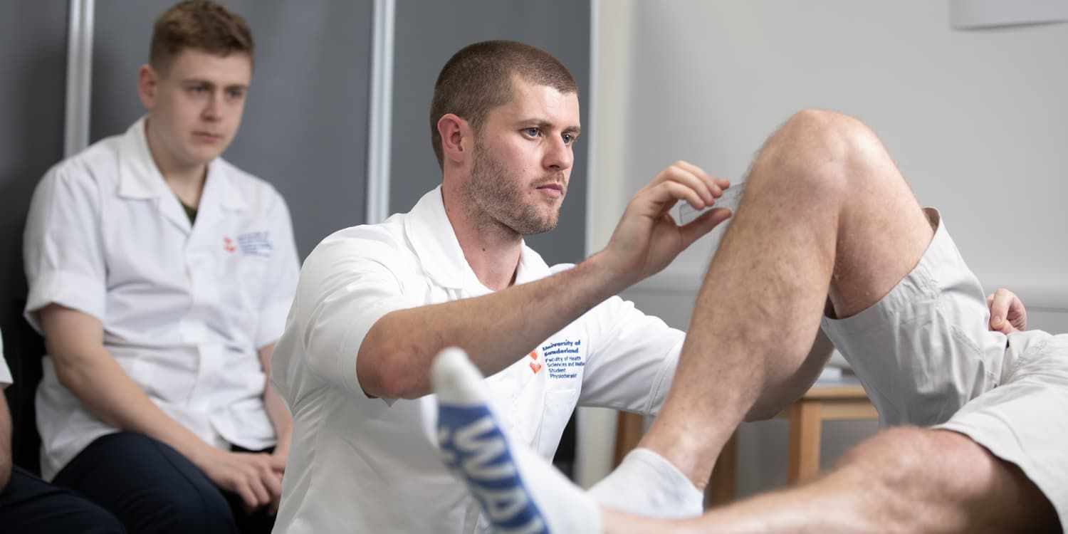 physiotherapy students practising on a patient