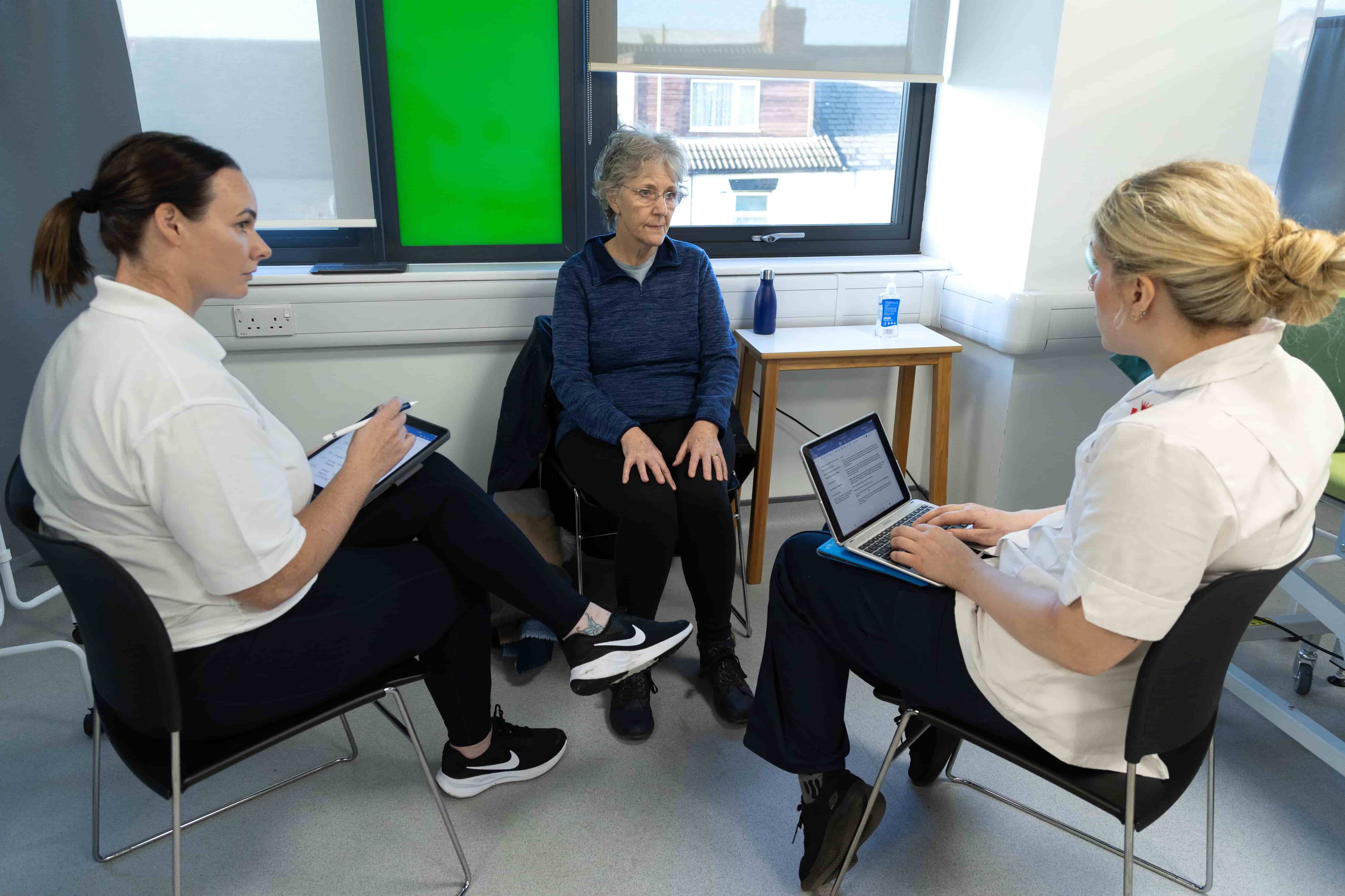 Two physiotherapy students talking with a PCPI patient during a seminar
