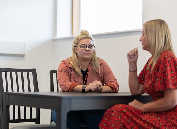 Two students sitting at a table in the Communication Skills Room