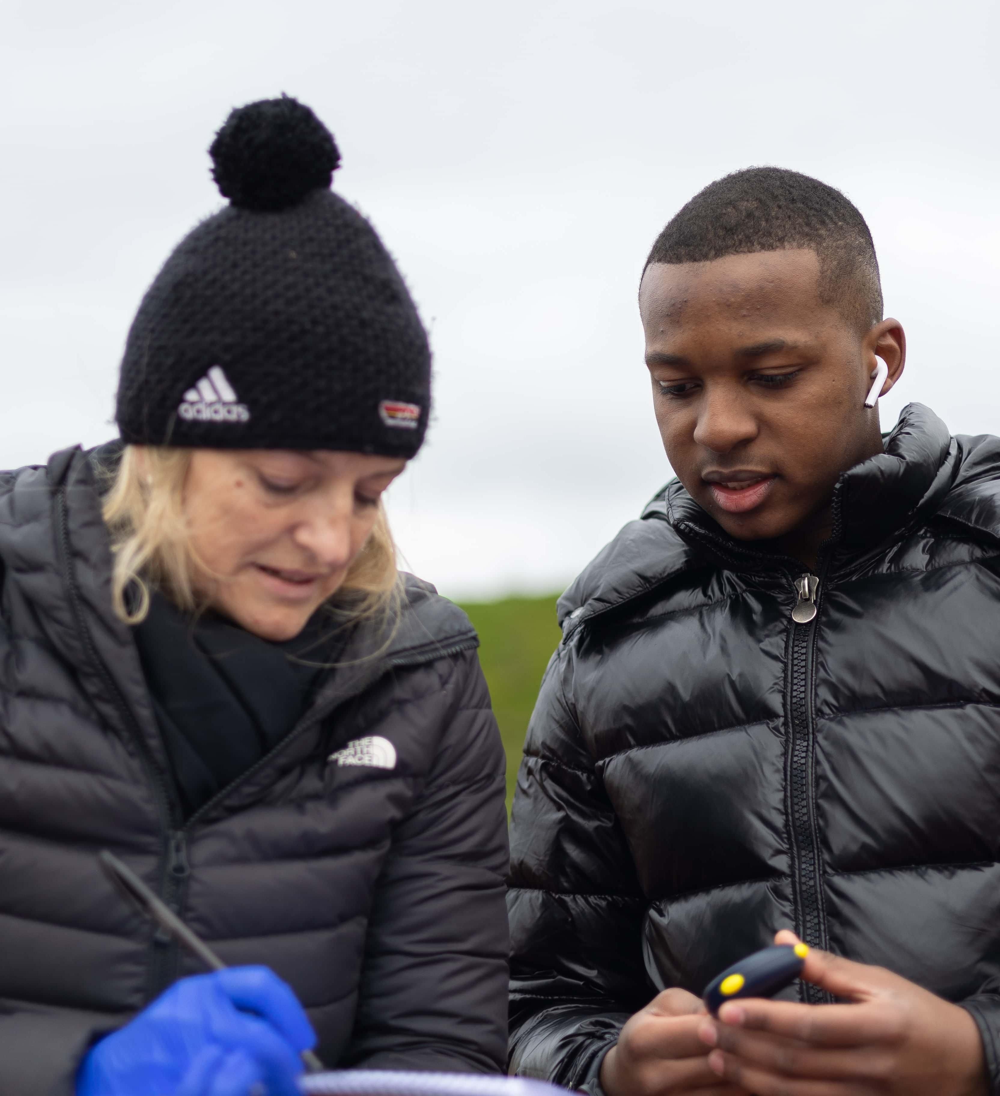 student and lecturer discussing results from a stopwatch