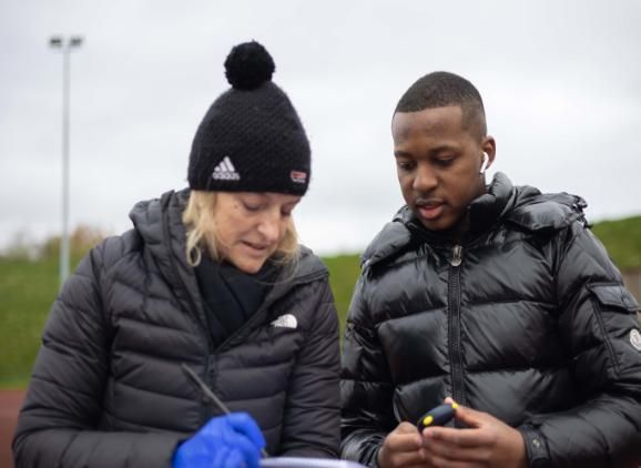 student and lecturer discussing results from a stopwatch