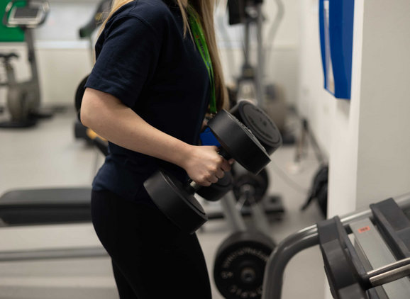 a student lifting weights off the rack