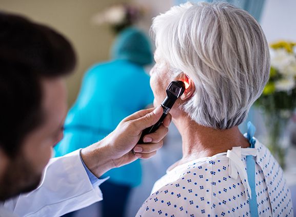 A doctor looking into a patient's ear